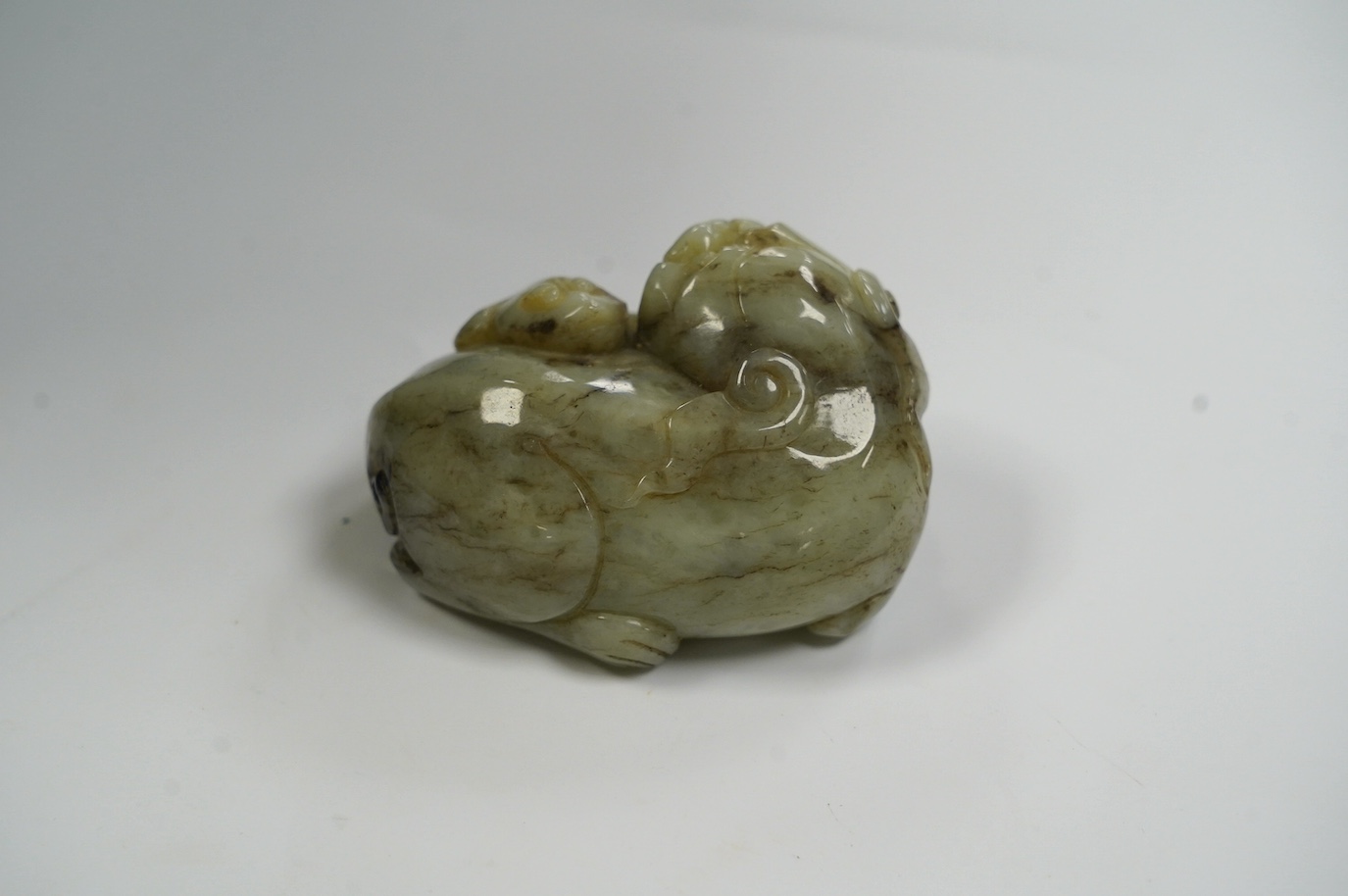 A Chinese jade figure of a lion-dog, 7.5cm wide, 4.3cm high. Condition - good